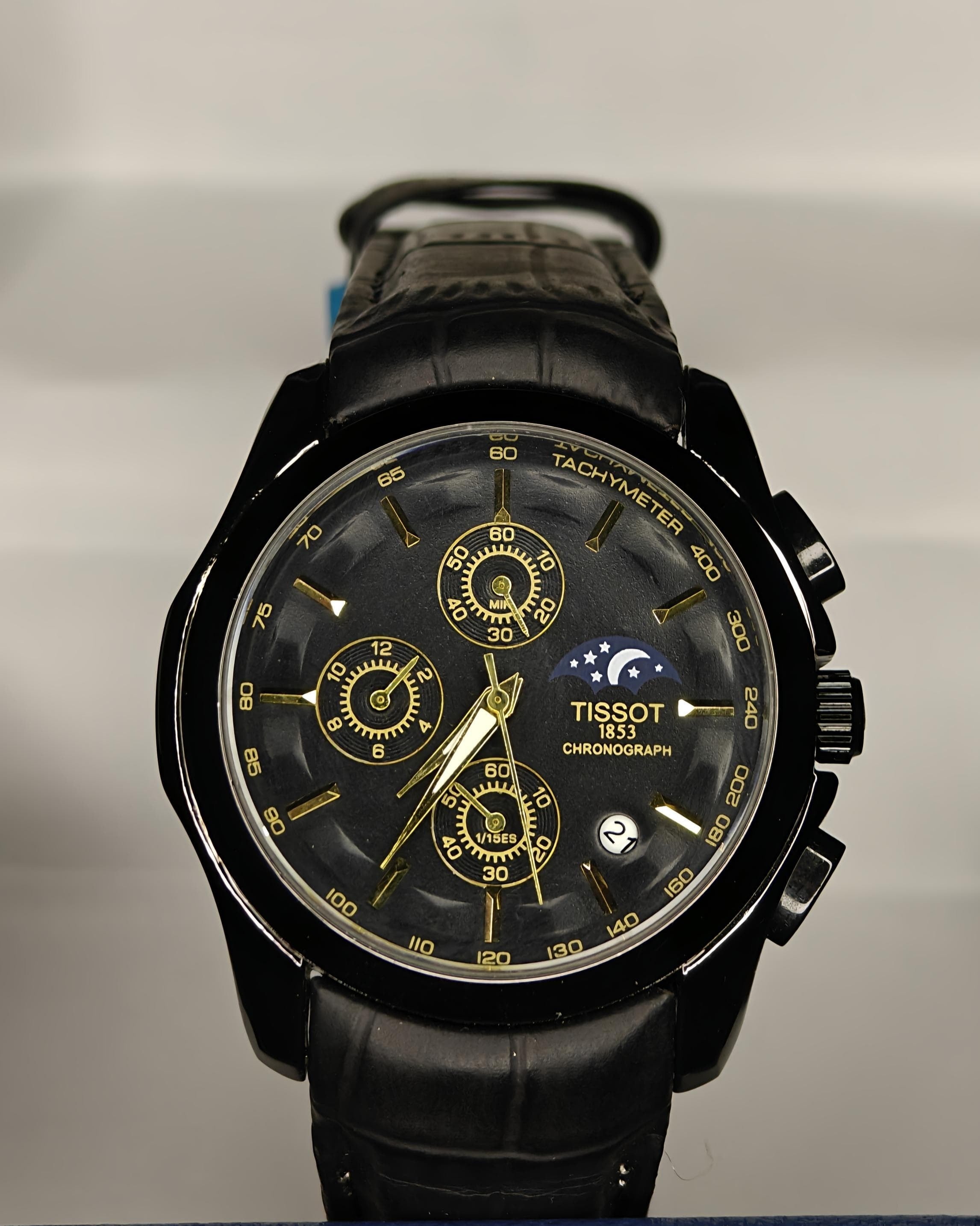 Black Tissot watch with detailed face on a branded background